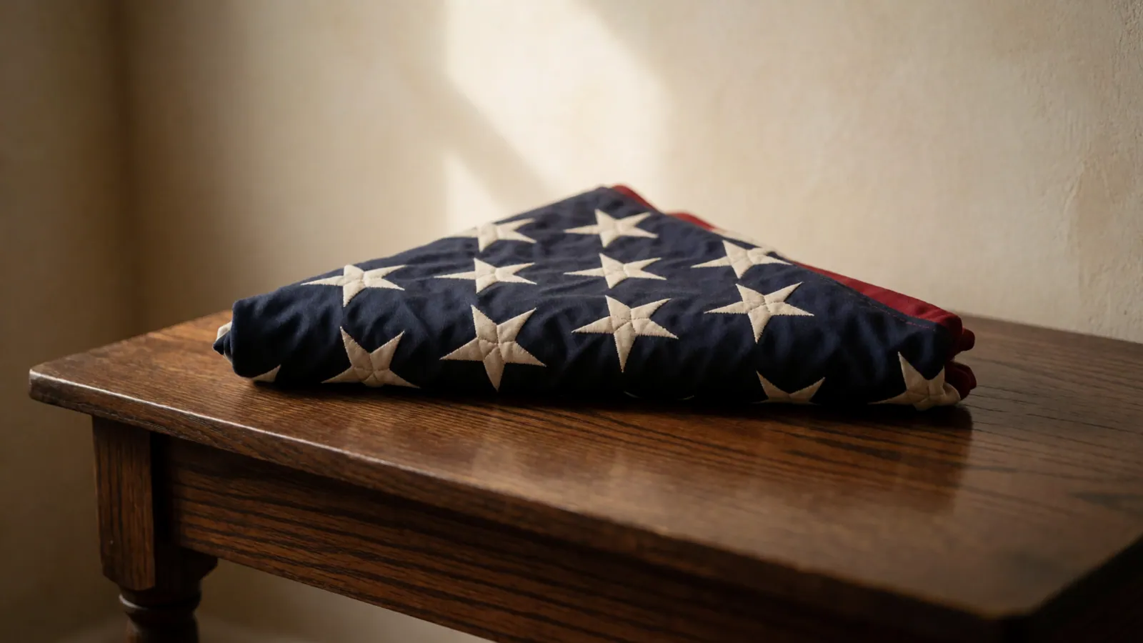 An American flag folded into a triangle on a dark polished table